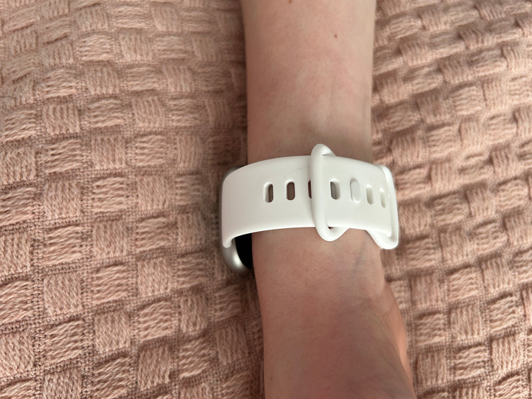 White Fitbit 4 wristband on a wrist