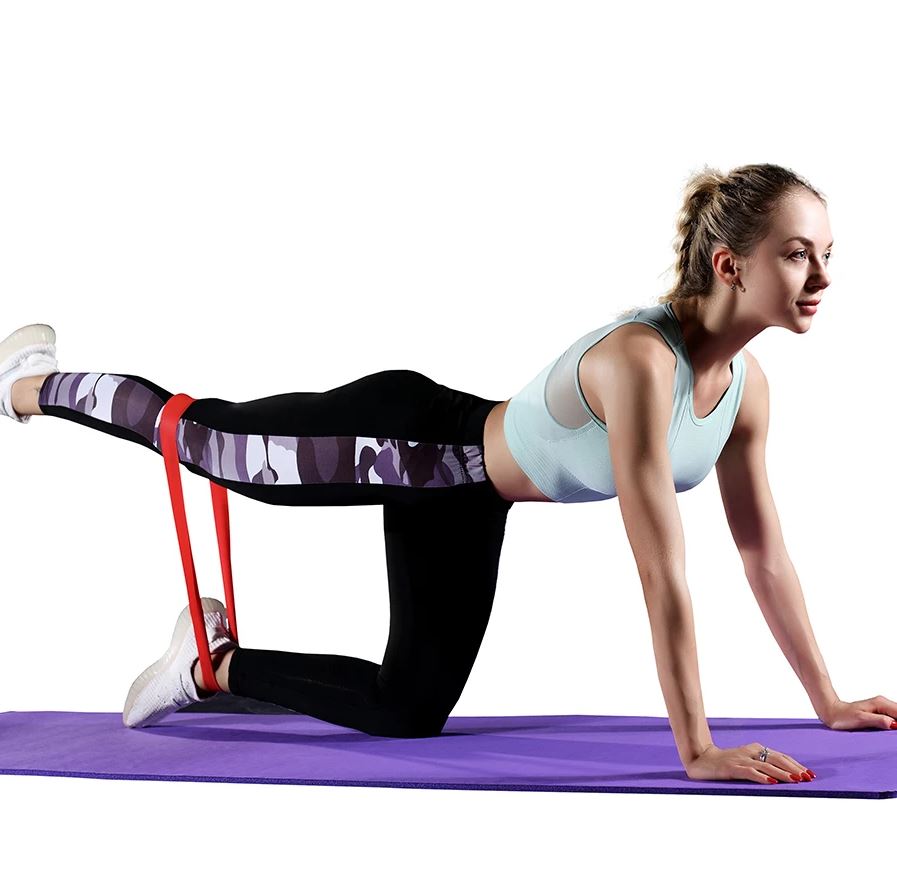 Woman exercising with a resistance band on a purple mat